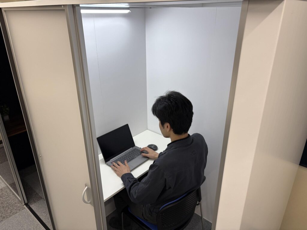 引き戸を開けたおもいっきり集中空間の内部でノートパソコンを使って作業している様子